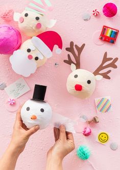 someone is decorating their christmas decorations with paper and felt snowman, reindeer, santa hat, candy canes