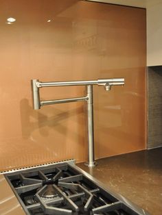 a stove top oven sitting inside of a kitchen next to a wall mounted faucet