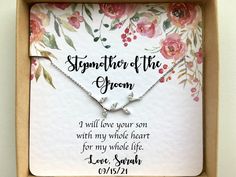 a personalized necklace in a box with flowers