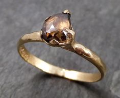 a gold ring with a brown diamond on it