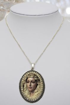 - Necklace of Saint Maria De La Estrella Vélez Malaga . I created this unique and meaningful necklace designs in honor of Saint Maria De La Estrella. Express your faith and devotion with this handmade piece it's a very powerful piece and a true gift for yourself or someone special. . Created With: Beautiful 57x37mm pendant with an image of Our Saint Maria De La Estrella with white rhinestones. Materials: Rhinestones & Metal . Please note this necklace its handmade by hands that love to creat Medallion Necklace For Memorial, Victorian Style Necklace With Large Pendant As Gift, Victorian Necklace With Large Pendant As Gift, Victorian Necklace With Large Pendant For Gift, Virgin Mary Necklace Aesthetic, Virgen Mary Necklace, Victorian Round Pendant Necklace For Memorial, Victorian Memorial Necklace With Round Pendant, Victorian Round Pendant Memorial Necklace