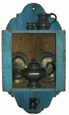 an old tea pot and kettle in a wooden box