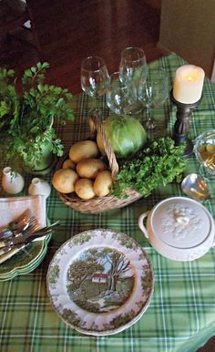 a table topped with plates and bowls filled with different types of food next to candles