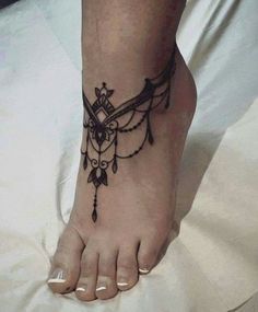 a woman's foot with an owl tattoo on the top and bottom of it