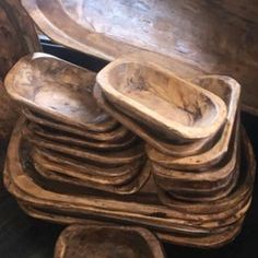 a stack of wooden bowls sitting on top of each other next to a chair and table