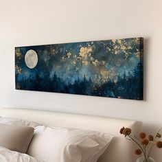 a painting hanging on the wall above a bed