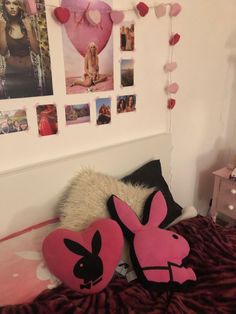 a bed with pink pillows and pictures on the wall above it, along with other decorations