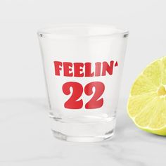 a shot glass with the word feelin'22 printed on it next to a lemon