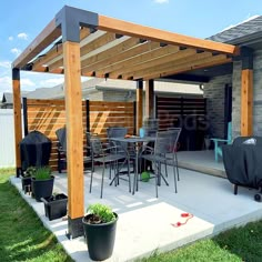 an outdoor patio with chairs, table and grill