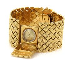 This is a stunning Retro Era wide watch bracelet, it is crafted from solid 18k yellow gold with a polished textured finish. It is wide and has a rectangular shape open and close cover for a small round Universal Geneve hand winding watch. There are small groove design box shape links fitted together in a symmetrical to form a 1.25 inches wide band, it fastens with a push in clasp with chain attach and latch for added security. Material: 18k yellow gold     Hallmark: Made Italy 18k Measurement: Universal Geneve, Design Box, Retro Era, Fancy Design, Design Bracelet, Gold Feathers, Heart And Key, Watch Bracelet, Tiffany And Co