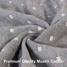 the fabric is grey and white with small squares on it, as well as an image of