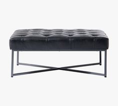 a black leather bench sitting on top of a metal frame