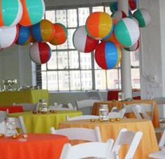 tables and chairs are decorated with colorful balloons