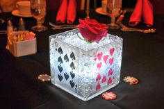 an ice block with a rose in it sitting on a table next to some wine glasses