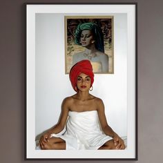 a woman sitting on the floor in front of a painting with a red turban