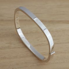 This is Solid 925 Sterling Silver Plain Square Shape Hinged Bangle Bracelet.  London Assay Office Hallmarked which is warranty for the purity being 925 sterling silver you  can be sure that you are buying genuine piece of jewellery.   Approx. weight: 11.5 grams.        Internal measures: 58mm x 51mm         Width: 5mm  Presented in gift box.    Thank you for looking! Classic Sterling Silver Bangle For Anniversary, Classic 925 Stamped Bangle For Anniversary, Classic Sterling Silver Bracelet For Anniversary, White Gold Sterling Silver Bangle Stamped 925, Anniversary Sterling Silver Bangle With Silver Clasp, Classic Sterling Silver Bangle Bracelet Gift, Classic Sterling Silver Bangle Stamped 925, Classic Silver Bangle With Sterling Clasp, Classic Hallmarked Sterling Silver Bangle Bracelet