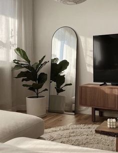 a living room with a couch, table and large television on the wall in front of it