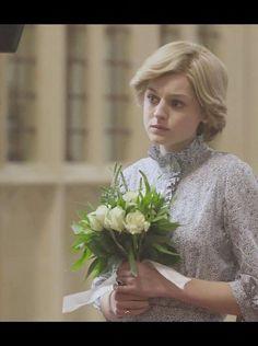 a woman holding a bouquet of flowers in her hand