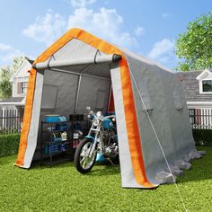 an inflatable tent is set up on the grass with a motorcycle parked inside