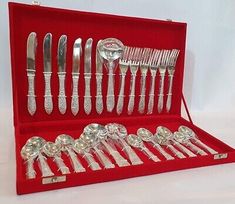 an assortment of silverware in a red case