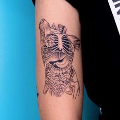 a woman's arm with a tattoo on it that has a skeleton and flowers