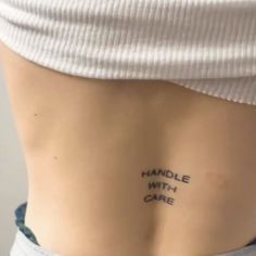 a woman's lower back with the words handle with care written on her left side