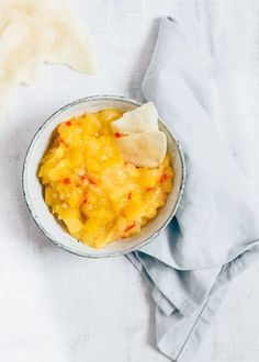 a bowl filled with macaroni and cheese on top of a white table cloth