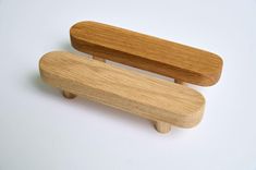 two wooden objects sitting side by side on a white surface