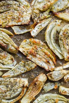 grilled artichokes with herbs and seasoning on a baking sheet in a pan