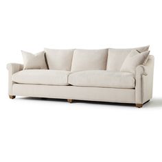 a white couch with two pillows on it's back and one arm facing the camera