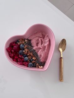 Strawberry mango smoothie heat shaped bowl topped with raspberry, blueberry, granola and chai seeds, served with a hold spoon. Pink Breakfast Ideas, Pink Healthy Food, Smoothie Bowls Aesthetic, Nutella Smoothie Bowl, Aesthetic Smoothie Bowl, Pink Fruit Bowl, Heart Bowl Aesthetic, Pink Smoothie Bowl Aesthetic, Strawberry Yogurt Bowl