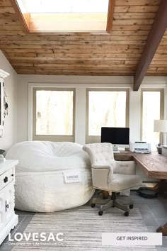 a large bean bag chair in the corner of a room with windows and a desk