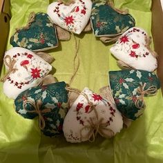 a box filled with heart shaped ornaments on top of a green cloth covered tablecloth