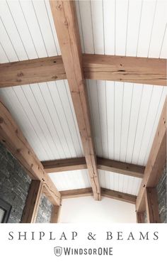 the inside of a building with white walls and wood beams on it's ceiling