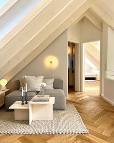 a living room filled with furniture under a loft style roof beam in an attic apartment