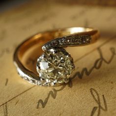 a diamond ring sitting on top of a piece of paper with writing underneath it that says love