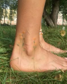 a close up of a person's bare foot in the grass