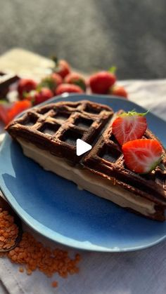 a waffle on a blue plate with strawberries