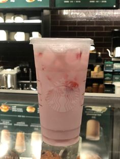 a starbucks drink in a plastic cup sitting on top of a counter