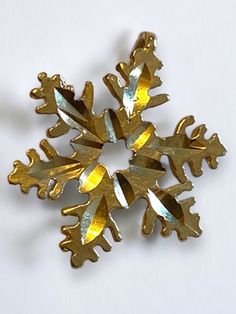 a gold colored snowflake is shown on a white surface with no other decorations