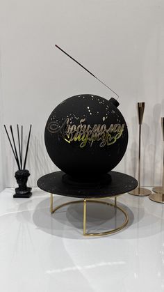 a black object with writing on it sitting on a table next to candles and vases