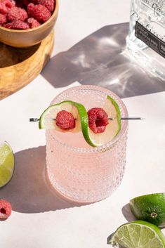 a raspberry margarita with limes on the rim and fresh raspberries