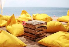 a bunch of yellow pillows on the beach