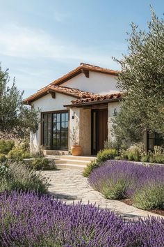 a house surrounded by lavender flowers and trees