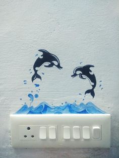 two dolphins jumping out of the water on a light switch