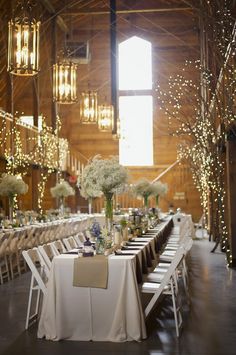 the tables are set up with white flowers and greenery