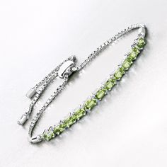 Peridot Bracelet, Genuine Peridot Oval Adjustable Bolo Bracelet in .925 Sterling Silver, Slider Bracelet, August Birthstone, Gift for Her Brighten up your jewelry collection with this 2.53-carat genuine peridot bolo bracelet, beautifully crafted in .925 sterling silver. The vibrant green peridot stones are arranged along an adjustable chain, bringing a fresh and lively touch to your ensemble. The bolo clasp ensures a perfect, comfortable fit, making this bracelet a versatile accessory that adds Green Oval Tennis Bracelet As Gift, Green Oval Tennis Bracelet For Gift, Luxury Peridot Bracelets For Gifts, Silver Bracelets With Peridot Gemstone, Elegant Silver Peridot Bracelets, Green Peridot Bracelet Jewelry, Silver Peridot Gemstone Bracelets, Adjustable Peridot Bracelet, Green Peridot Multi-stone Jewelry