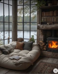 a living room filled with furniture and a fire place in front of a large window