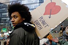 a man holding a cardboard box with an i love planet sign on it's back