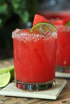 two glasses filled with watermelon margaritas and lime wedged in the middle